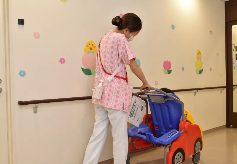 画像:看護師が子ども用椅子を運んでいる