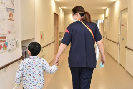 画像:小児救急看護の看護師と子どもが手を繋いで歩いている
